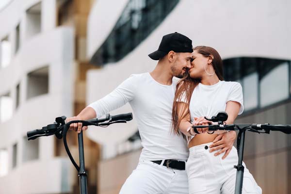 A couple on electric scooters embrace in the city 2021 07 30 16 47 16 utc min