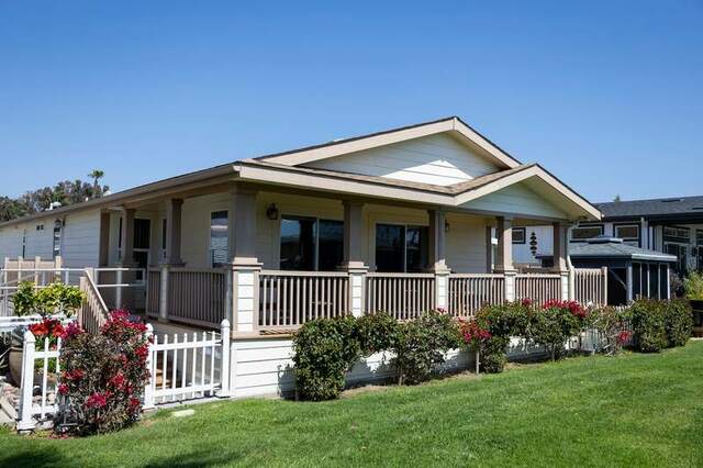 Front of manufactured home with porch and garden display